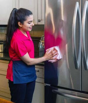 Woman cleaning outside of refrigerator