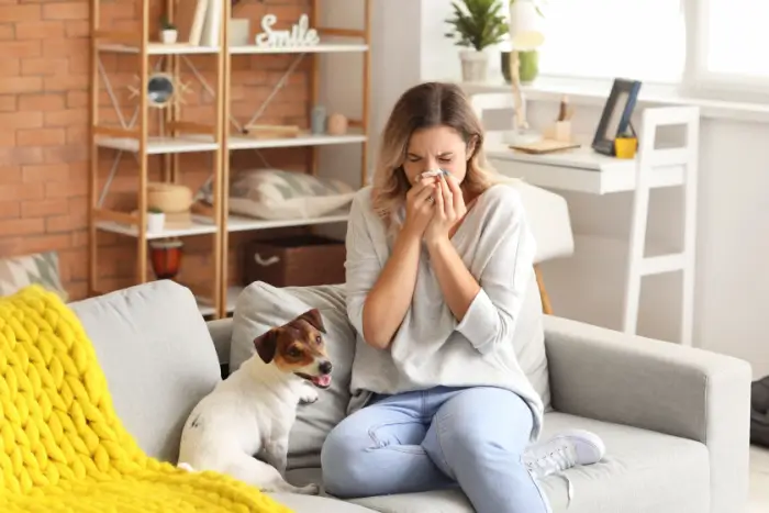 Woman blowing her nose from allergens in her home.