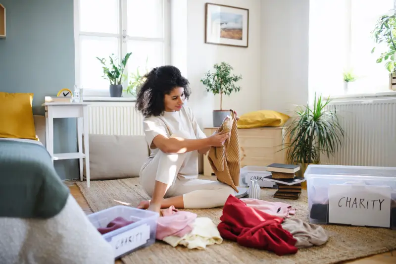 Woman sorting clothes in her living room.