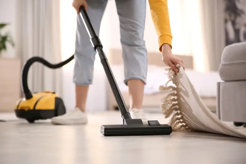 Woman vacuuming her living room floor.