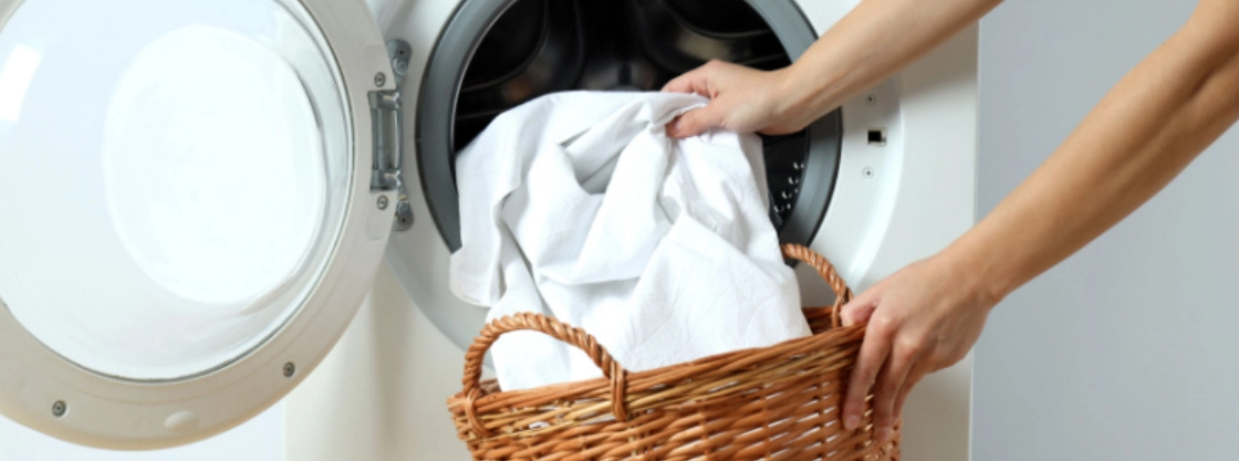 Person taking comforter out of washing machine.