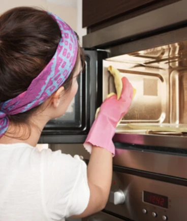 woman cleaning a microwave.