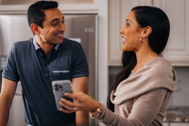 Couple in their kitchen booking a cleaning appointment with Molly Maid.