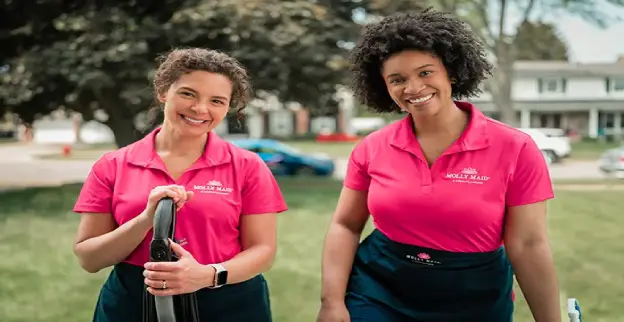 Molly Maid professionals outside smiling before providing residential cleaning services.