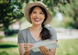 Smiling woman holding a Molly Maid gift certificate.