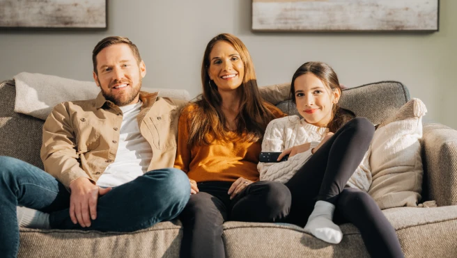 happy family sitting on a living room couch together.