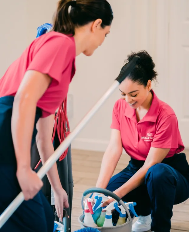 Molly Maid professionals cleaning the entryway of a home.