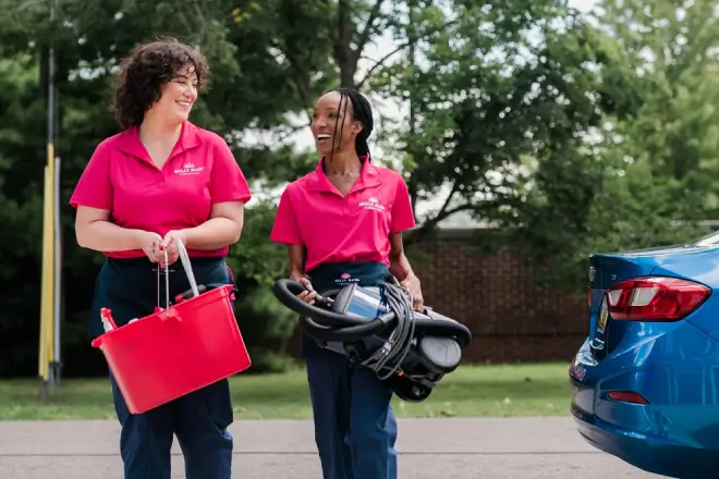 2 Molly Maid service professionals walking up to a residential cleaning appointment.