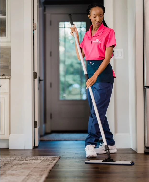 Molly Maid professional cleaning a floor.