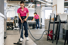 Molly Maids cleaning a commercial business with a vacuum.