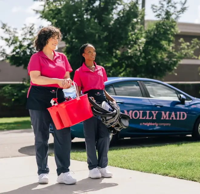 Two Molly Maid professionals walking up to a customer's home.