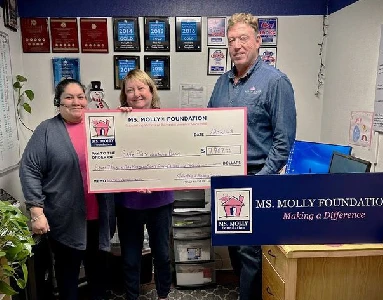 Molly Maid employees holding a large check.