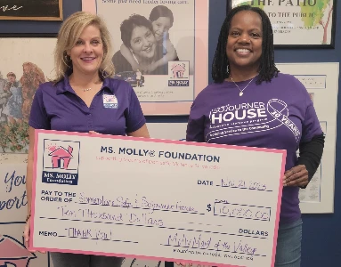 Two people holding a large check.