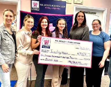 Smiling group of people holding a large check.