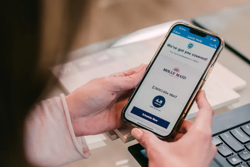 Customer using a phone to book an appointment with Molly Maid.