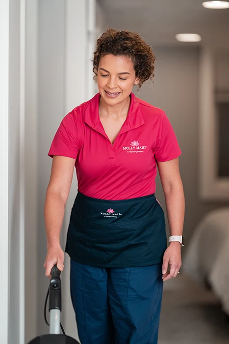 A Molly Maid professional vacuuming during a condo cleaning appointment