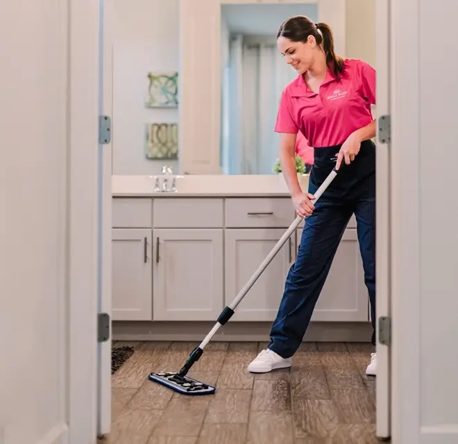 Molly Maid professional mopping a bathroom floor.