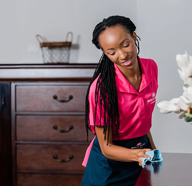 Maid cleaning a table.