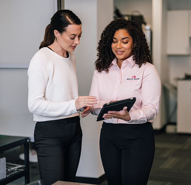 Molly Maid professional going over a cleaning plan with a business customer.