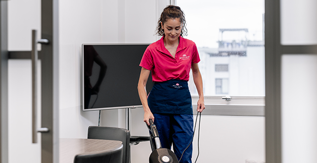 Molly Maid employee cleaning a small business office.