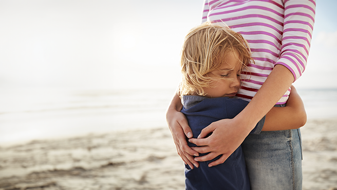 Mother and son hugging.