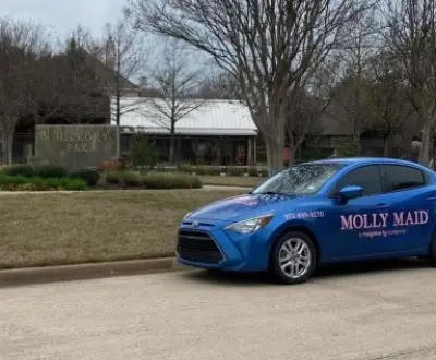 Molly maid car in front of a house.