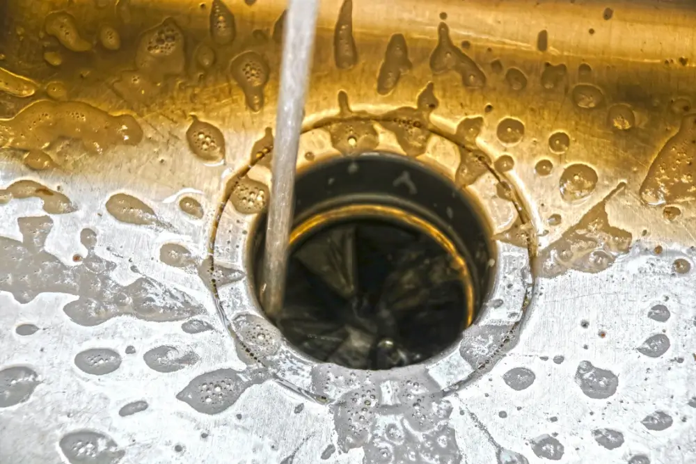 Water flowing from a sink into a garbage disposal.