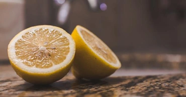 A lemon sliced into halves on a countertop.