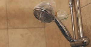 A showerhead covered by a bag filled with vinegar