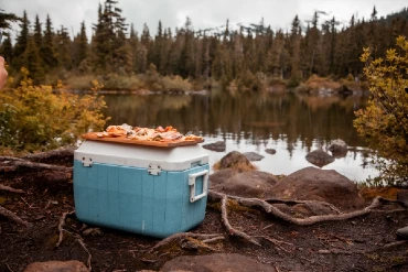 cooler by a lake with mountains in distance