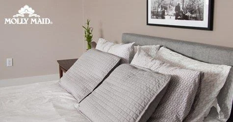 A well-made bed with assorted pillows,