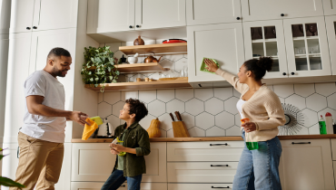 A family working together to clean a kitchen.