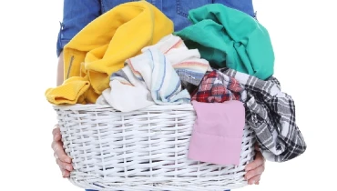 Woman holding a wicker basket full of laundry