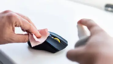 Person wiping computer mouse with rag