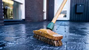 Close up of broom cleaning porch outside of a house