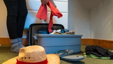 Person pulling clothes out of a plastic bin