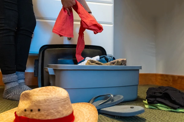 Person pulling clothes out of a plastic bin