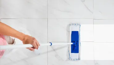 Overhead view of person cleaning a tile floor with a mop