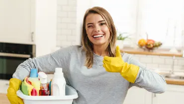 Woman holding thumbs up while cleaning