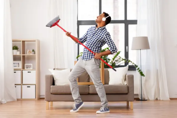 Man cleaning his house and listening to music