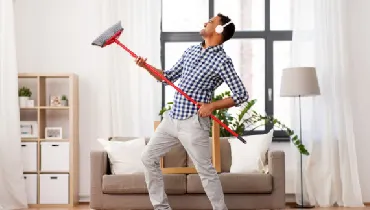 Man cleaning his house and listening to music