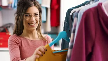 Woman hanging up clothes in her bedroom closet