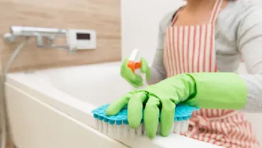 Woman deep cleaning bathroom tub