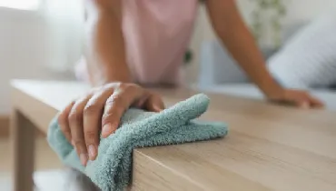 Woman cleaning and wiping the table with microfiber cloth