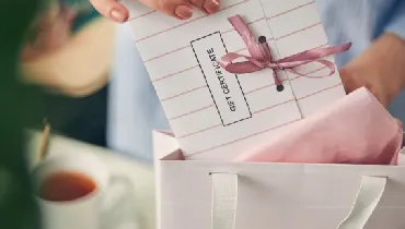 Woman packaging a gift certificate in a paper bag