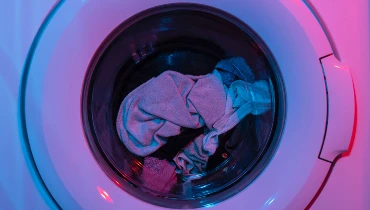 Clothes in a front-loading washing machine. Photo by engin akyurt on Unsplash.