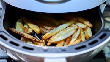 Overhead view of French fries cooked in an air fryer.