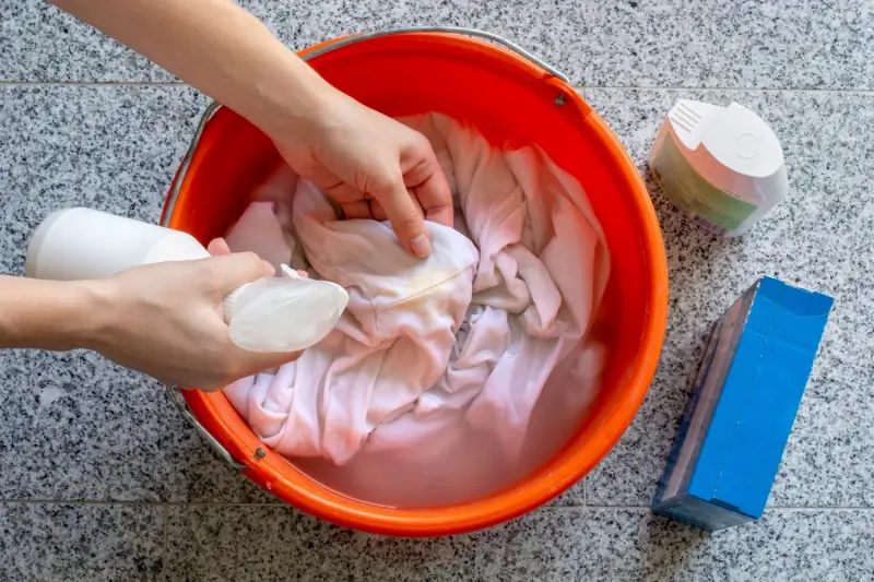 Laundry being hand washed in a bucket.